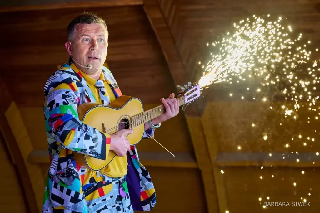 Bogdan Michalec wykonuje numer z gitarą i pirotechniką sceniczną.